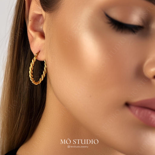 model wearing large twisted rope hoop earrings in silver