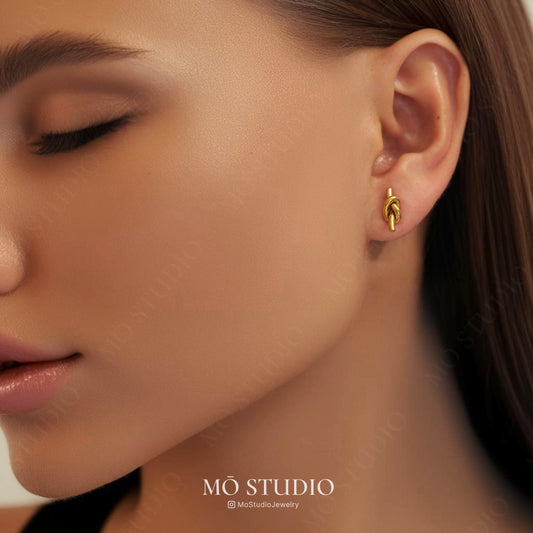 model wearing delicate gold knot earrings
