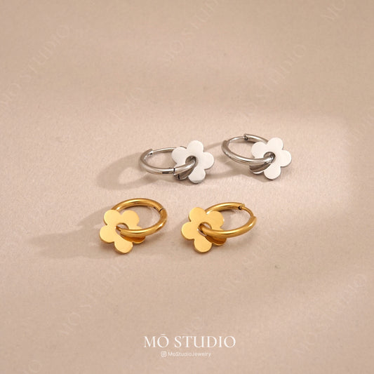 gold and silver daisy flower hoop earrings on white background